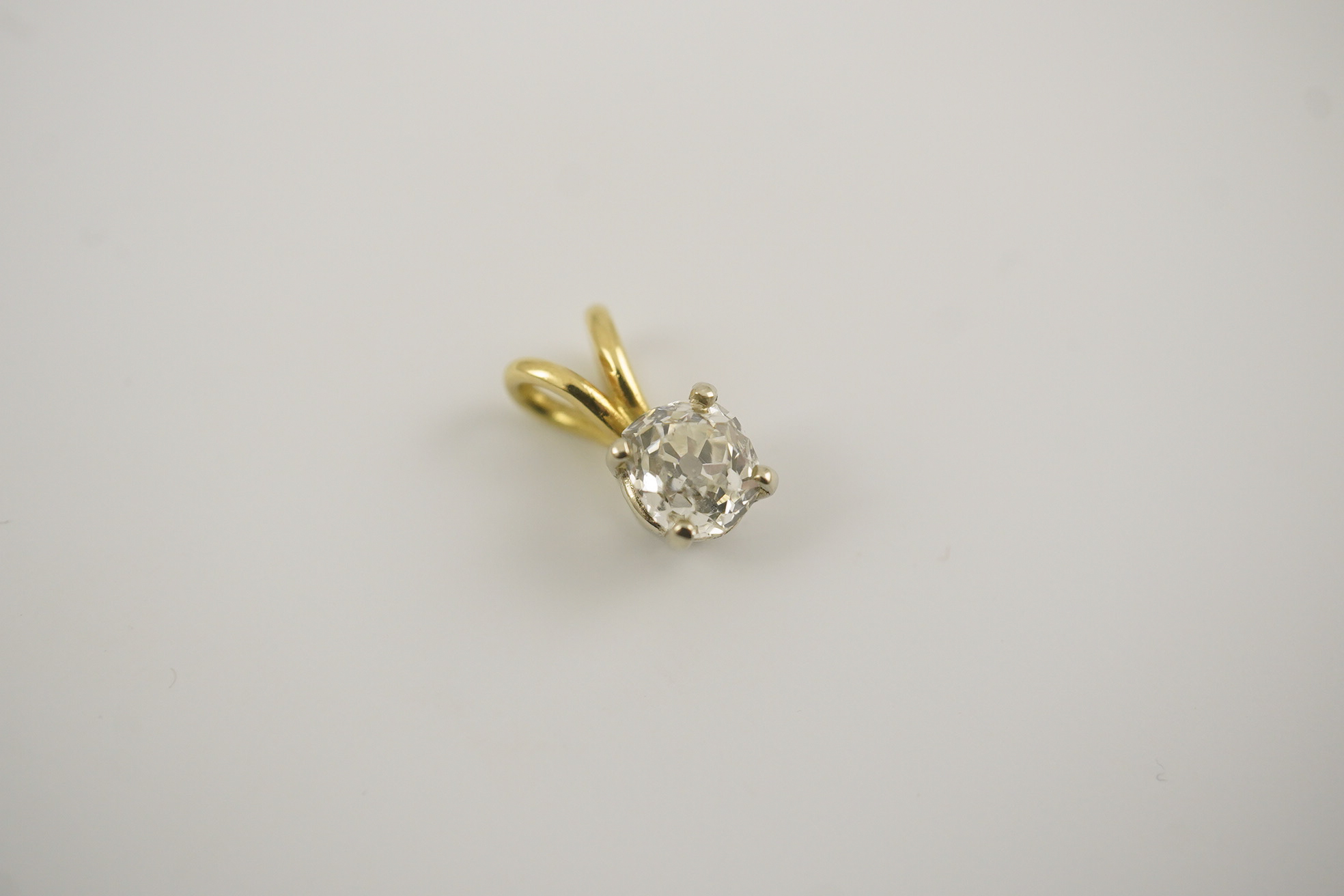 A gold and solitaire diamond set small pendant